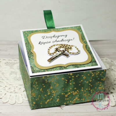 pudełko kaskadowe, w centrum znajduje się napis Dziękujemy księże (imię księdza) a pod spodem jest różaniec. Pudełko wykonane w odcieniach zieleni. Elementy z pudełka wyciągane są za pomocą zielonej wstążki