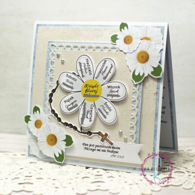 kartka kwadratowa a w jej centrum duża margaretka. Na każdym płatku imię osoby modlącej się za księdza, a w centrum kwiatka imię księdza. Z lewej strony margaretki jest różaniec. W prawym górnym rogu i w dolnym lewym rogu kartki są 3 papierowe grafiki margaretek. Kartka jest w kolorystyce błękitno kremowej