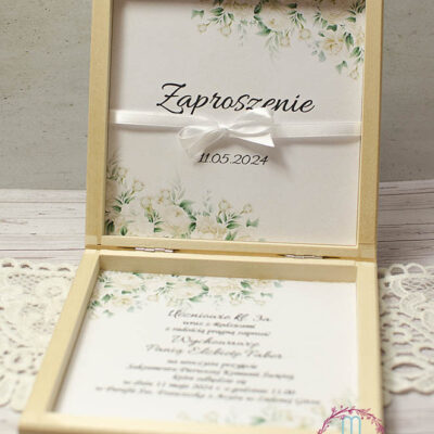 środek drewnianego pudełka, na górnej części napis zaproszenie + data i przewiązane białą delikatną wstążką, na dole pudełka treść zaproszenia