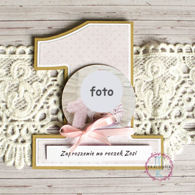 zaproszenie w kształcie cyfry 1. Zaproszenie na brązowym papierze craft a na nim jest różowy papier w kropki. w centralnym miejscu zaproszenia jest okrągło zdjęcie dziecka, poniżej jest różowa wstążka a na samym dole napis: zaproszenie imię dziecka