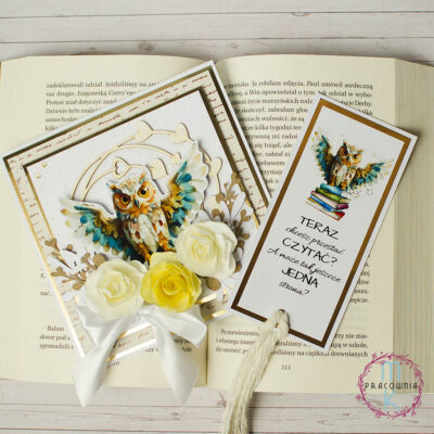 Kartka kwadratowa. W środkowej części znajduje się sowa z rozpostartymi skrzydłami, pod nią kwiaty 3 D w odcieniach kremu i żółtego. Wokół sowy znajduje się ramka z serduszkami. Obok kartki znajduje się zakładka z tą samą sową i z cytatem