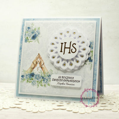 Kartka okolicznościowa z okazji 22. rocznicy święceń kapłańskich, w odcieniach błękitu, z grafiką złożonych dłoni do modlitwy i różańcem. Personalizowana, zapakowana z białą kopertą. Format kwadratowy.