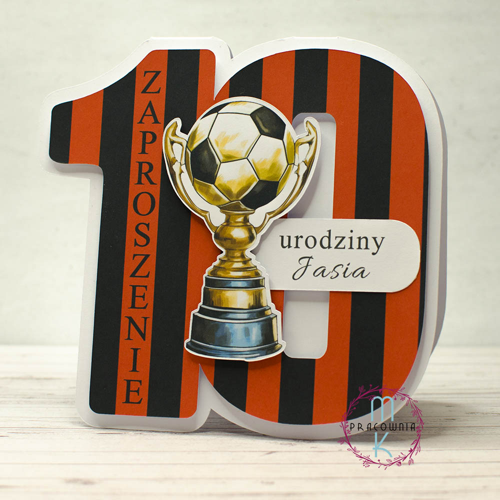_DSC7046_www zaproszenie w kształcie cyfry 10 w kolorach biało czerwonych w paski. Na środku znajduje się puchar z piłką nożną, na prawo od niego napis Urodziny Jasia. Wzdłuż cyfry 1 znajduje się napis: Zaproszenie