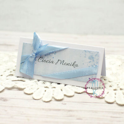 niebieskie winietki na stół z przewiązaną niebieską wstążką