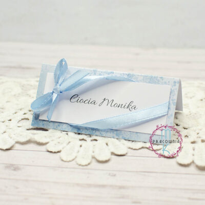 niebieskie winietki na stół z przewiązaną niebieską wstążką