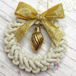 wianek z makramy ze złotą kokardą i złotą bombką w środku
